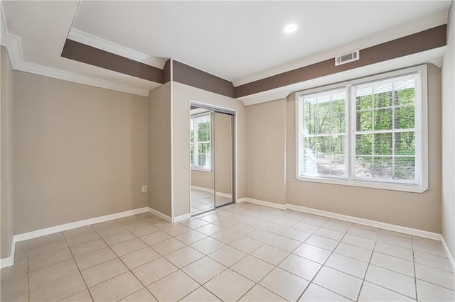empty room featuring recessed lighting, visible vents, light tile patterned floors, crown molding, and baseboards