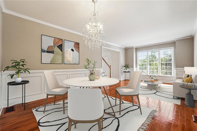 dining area with visible vents, a wainscoted wall, wood finished floors, and crown molding