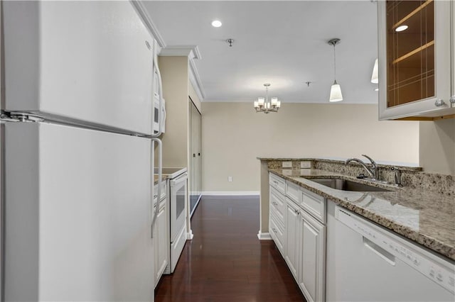 kitchen with crown molding, dark wood-type flooring, light stone countertops, white appliances, and sink