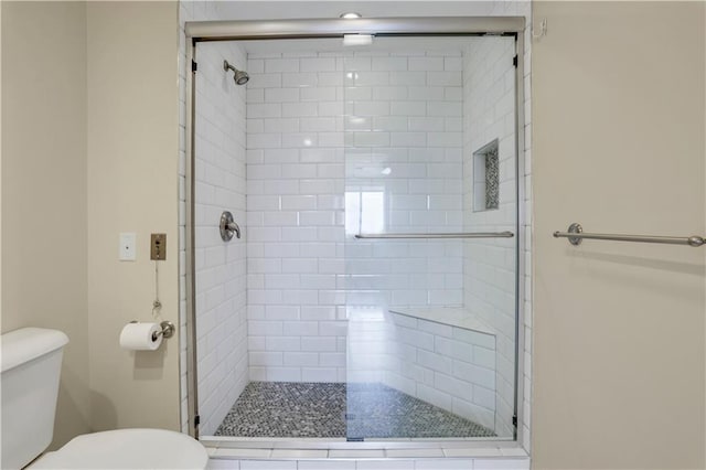 bathroom with toilet and an enclosed shower