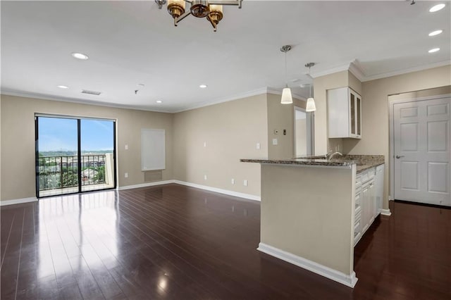 kitchen featuring white cabinetry, dark hardwood / wood-style floors, hanging light fixtures, and light stone countertops