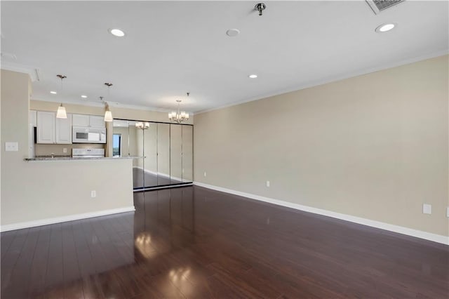 unfurnished living room featuring dark hardwood / wood-style flooring, a chandelier, and ornamental molding