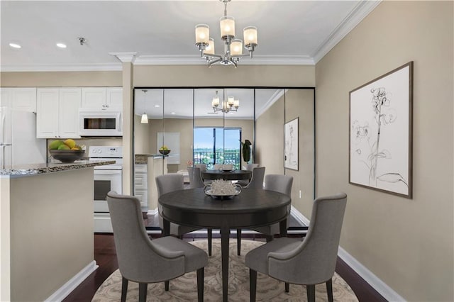 dining area featuring dark hardwood / wood-style floors, an inviting chandelier, and crown molding