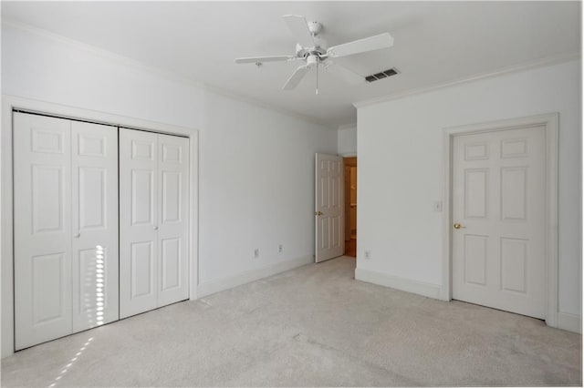 unfurnished bedroom featuring light carpet, a closet, ornamental molding, and ceiling fan