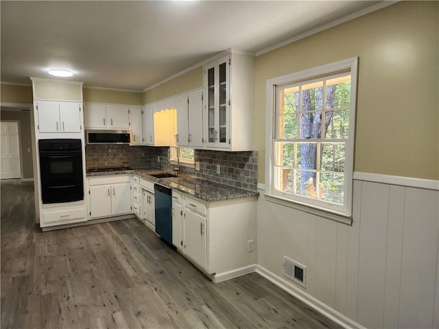 kitchen with extractor fan, sink, light stone counters, white cabinets, and black appliances