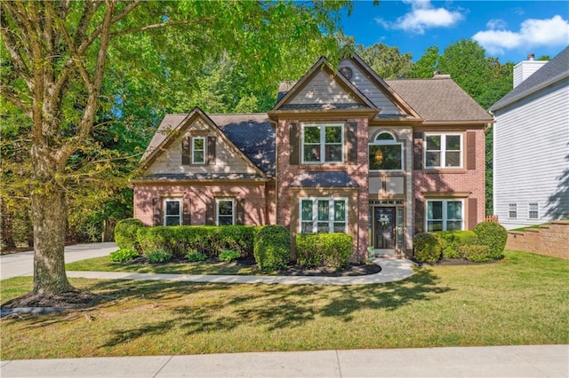 view of front facade featuring a front yard and brick siding