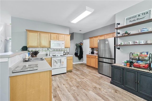 kitchen with white appliances, light brown cabinetry, a sink, and light wood-type flooring
