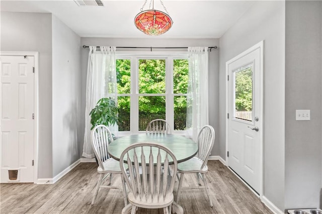 dining area with baseboards and wood finished floors