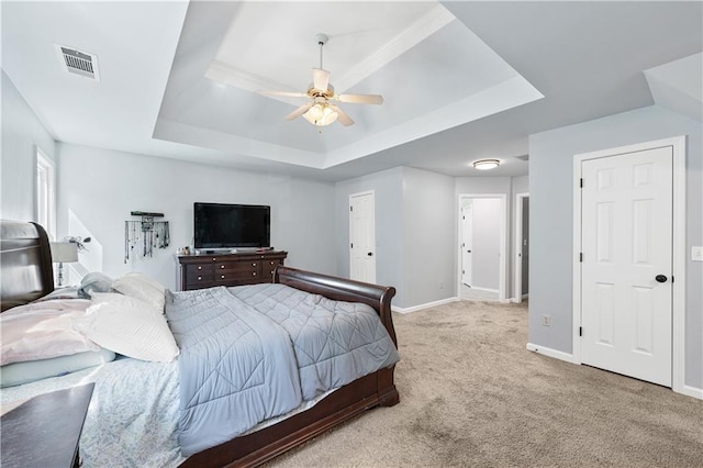 bedroom with a raised ceiling, carpet flooring, baseboards, and a ceiling fan