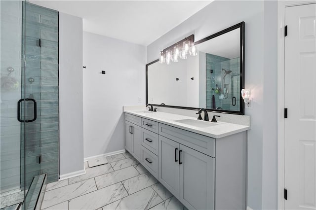full bath featuring marble look tiles, a shower stall, baseboards, and double vanity