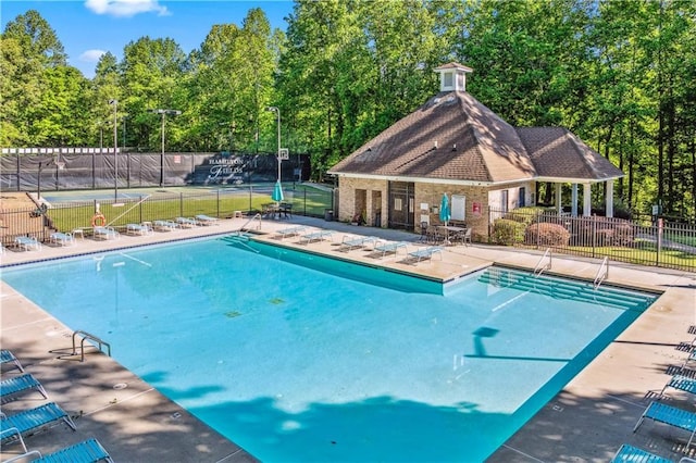 community pool with fence and a patio area