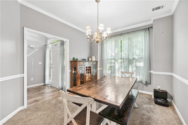 carpeted dining space featuring crown molding, a chandelier, and baseboards