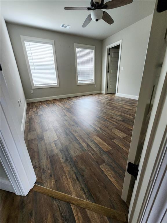 spare room with dark hardwood / wood-style flooring and ceiling fan