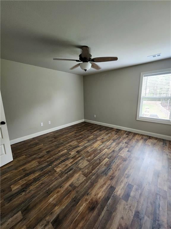 spare room with ceiling fan and dark hardwood / wood-style flooring