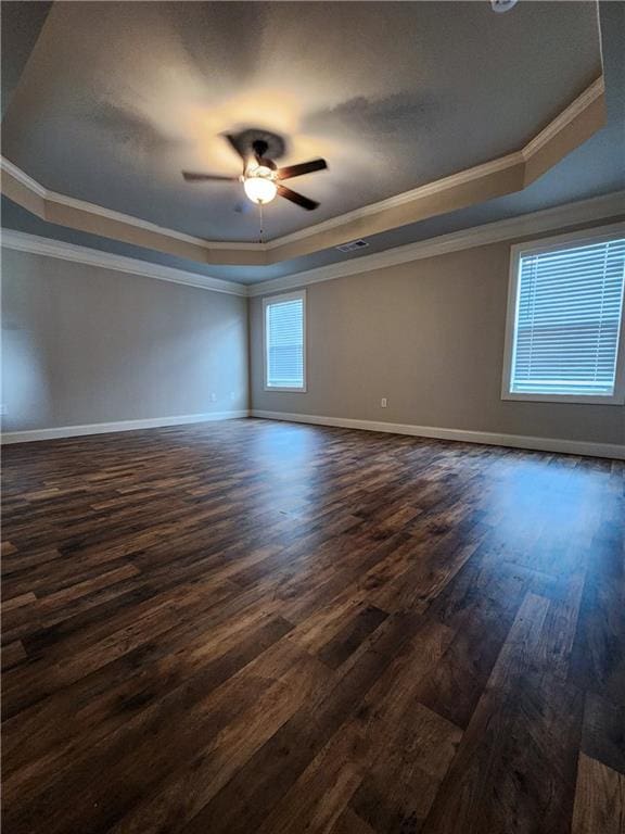 unfurnished room with ornamental molding, ceiling fan, a raised ceiling, and dark hardwood / wood-style floors