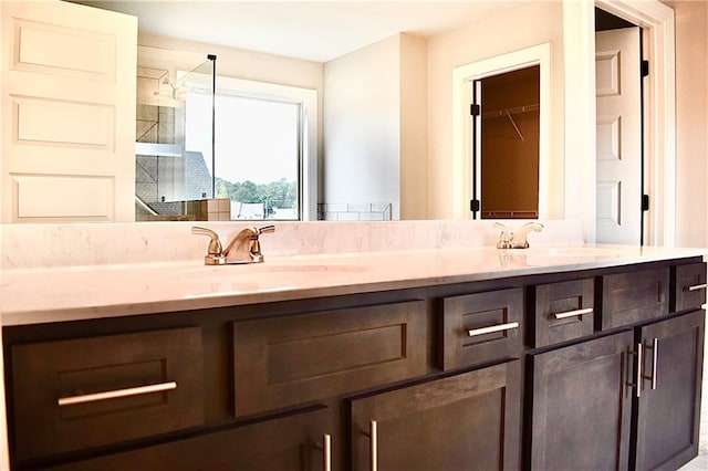 bathroom featuring walk in shower and vanity