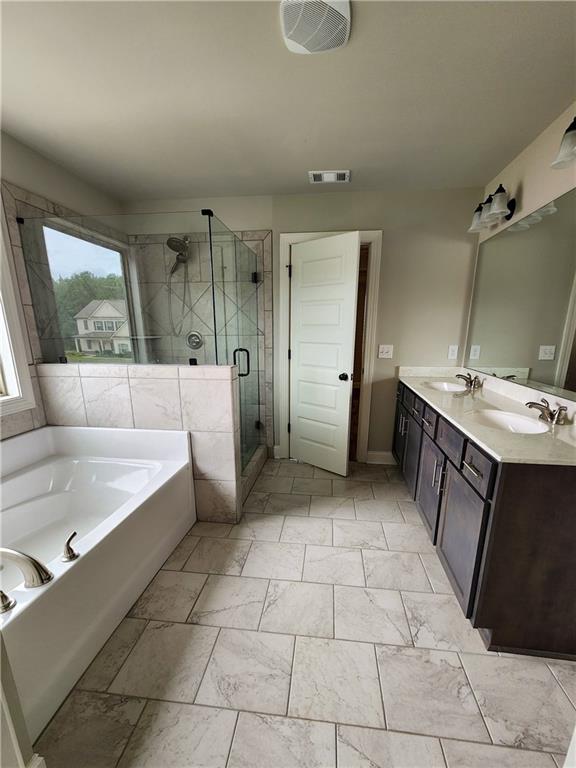 bathroom with vanity and separate shower and tub