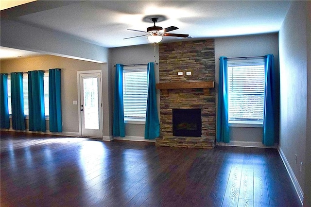 unfurnished living room with ceiling fan, a fireplace, and dark hardwood / wood-style flooring