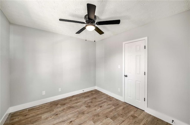 empty room featuring hardwood / wood-style floors, a textured ceiling, and ceiling fan