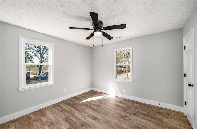 spare room with hardwood / wood-style flooring, a textured ceiling, and ceiling fan