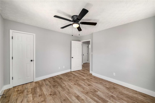 unfurnished bedroom with light wood-type flooring, ceiling fan, and a textured ceiling