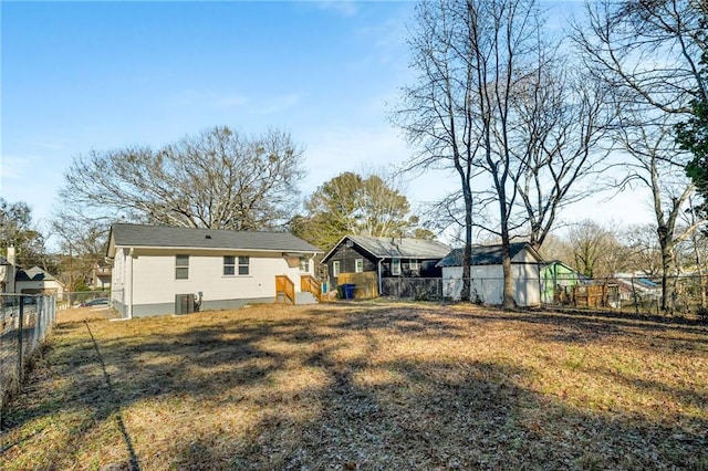 back of house featuring a yard and central AC