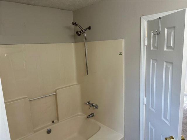 full bathroom with a textured ceiling and shower / washtub combination