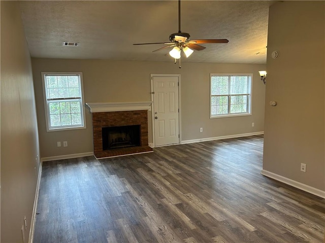 unfurnished living room featuring dark wood-style floors, visible vents, and a textured ceiling