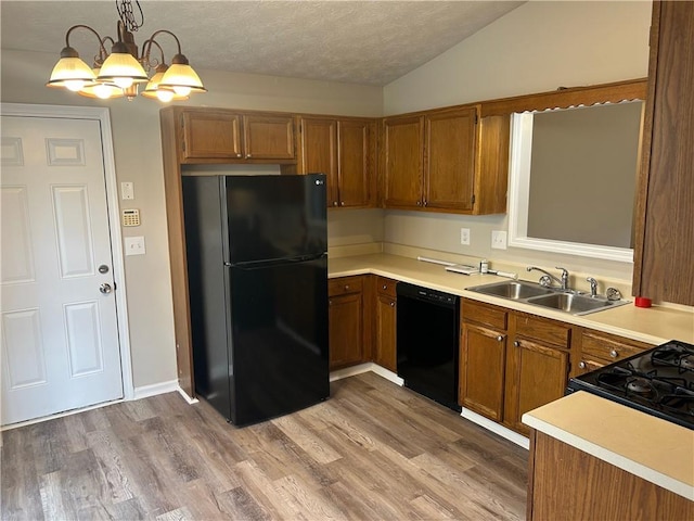 kitchen with black appliances, brown cabinetry, and a sink