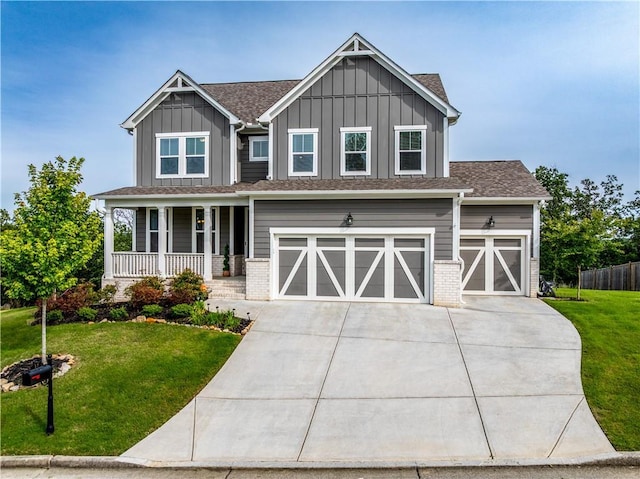 craftsman-style home with board and batten siding, a porch, driveway, and a front lawn