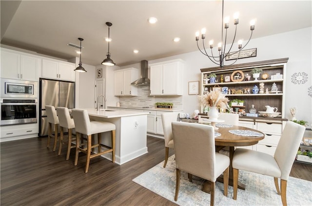 dining area with a chandelier, dark wood finished floors, and recessed lighting