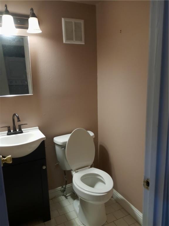 bathroom with tile flooring, vanity, and toilet