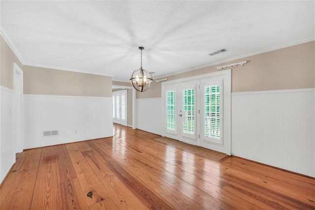 280 W Knight Rd W, Mcdonough, GA 30252 - empty room featuring a chandelier, wainscoting, hardwood / wood-style floors, and crown molding