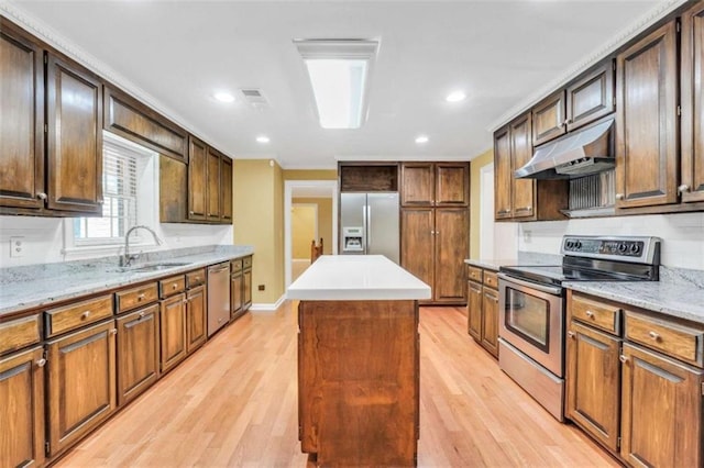 280 W Knight Rd W, Mcdonough, GA 30252 - kitchen with appliances with stainless steel finishes, under cabinet range hood, a kitchen island, light wood-style floors, and tasteful backsplash