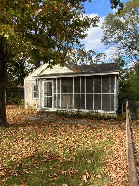 rear view of property featuring a sunroom