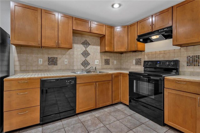 2551 Tolliver Dr, Ellenwood, GA 30294 - kitchen with black appliances, under cabinet range hood, a sink, backsplash, and tile countertops