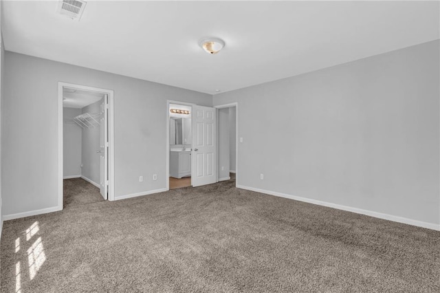 2551 Tolliver Dr, Ellenwood, GA 30294 - unfurnished bedroom featuring a walk in closet, visible vents, carpet, and baseboards