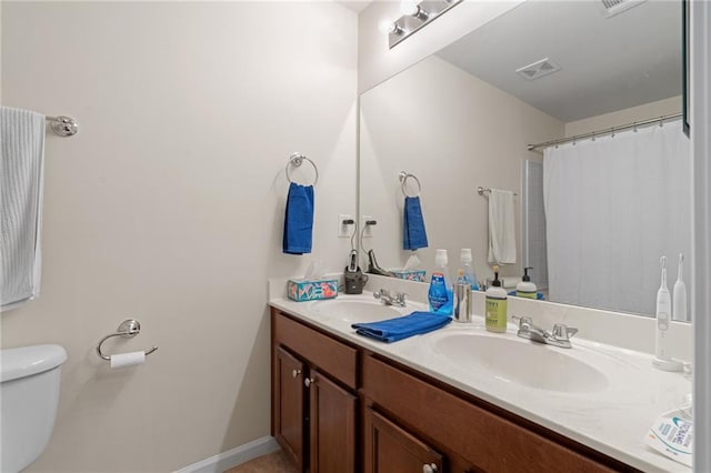 bathroom featuring toilet, curtained shower, and vanity