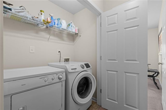 clothes washing area with washing machine and dryer and baseboards