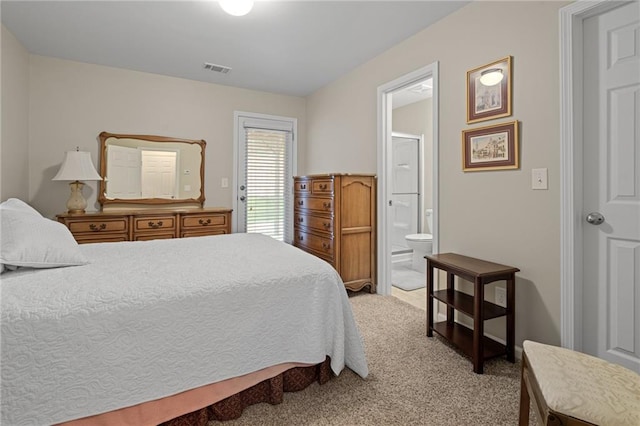 bedroom featuring connected bathroom and light colored carpet