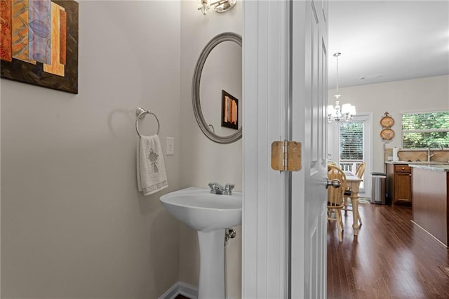 bathroom featuring sink, hardwood / wood-style floors, and an inviting chandelier