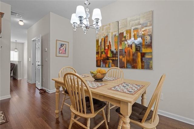 dining space featuring a chandelier, wood finished floors, and baseboards