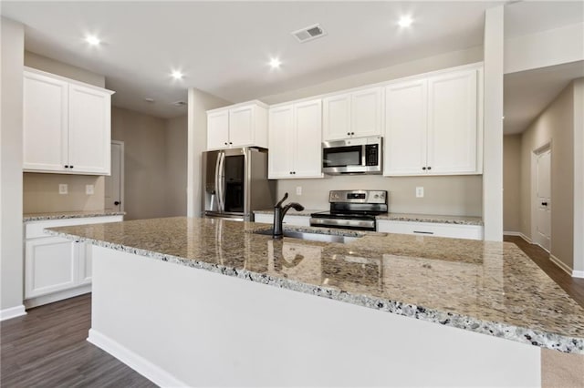 kitchen featuring visible vents, a center island with sink, recessed lighting, stainless steel appliances, and dark wood-style flooring