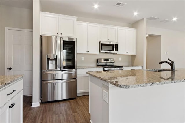 kitchen with visible vents, dark wood finished floors, a sink, stainless steel appliances, and white cabinetry