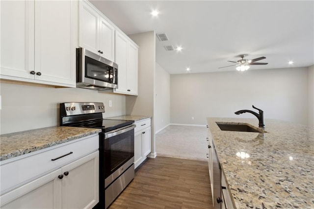 kitchen featuring visible vents, dark wood-type flooring, a sink, white cabinetry, and appliances with stainless steel finishes