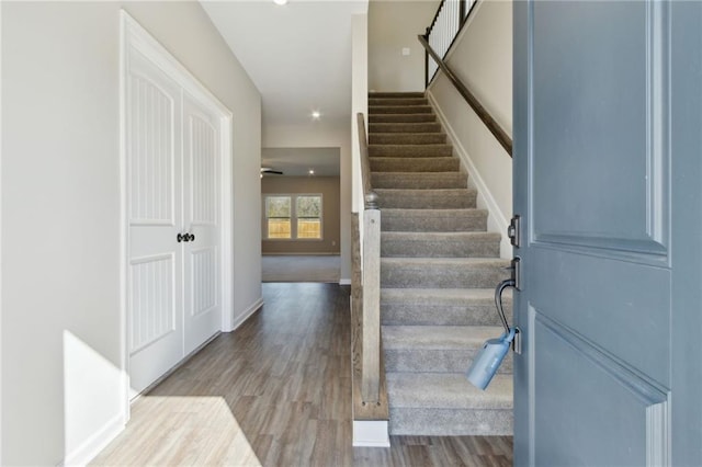 stairway with wood finished floors and baseboards