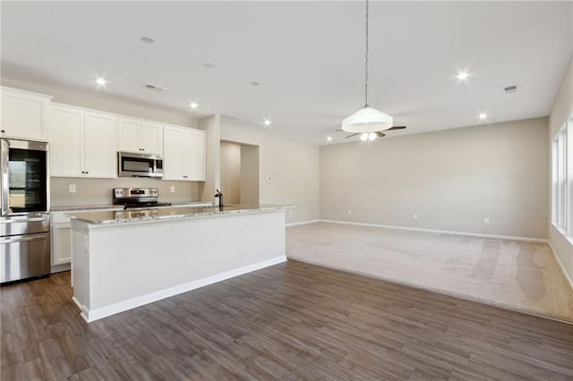 kitchen featuring recessed lighting, appliances with stainless steel finishes, an island with sink, and white cabinets