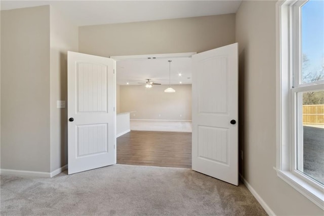 carpeted empty room featuring baseboards