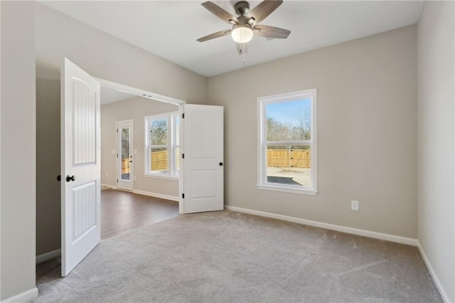 empty room with ceiling fan, baseboards, and carpet floors