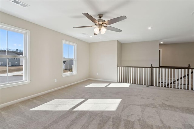 empty room with baseboards, visible vents, carpet floors, and a healthy amount of sunlight